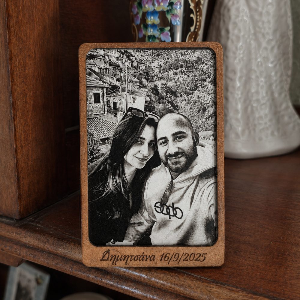 Photo of a couple engraved on aluminium in a wooden frame, with a place name and date engraved beneath it