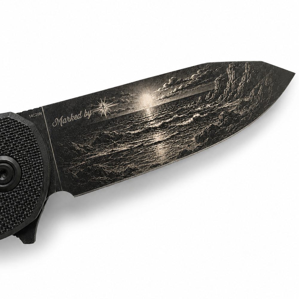 Sunset seascape with waves and cliffs engraved along a folding knife blade