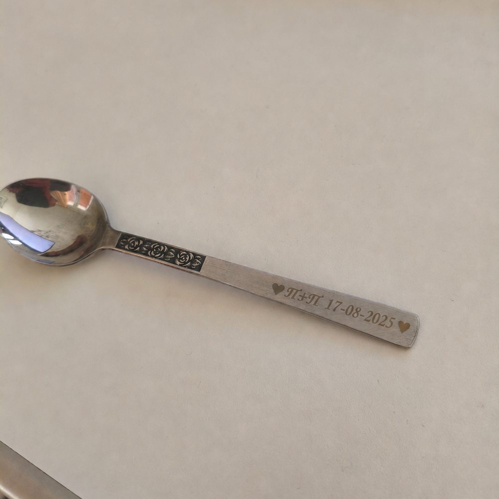 Spoon handle engraved with a couple's initials, their wedding date and two hearts